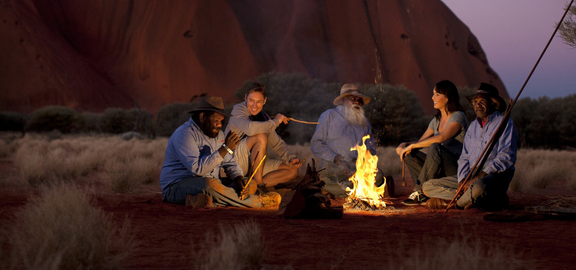 Sitting around a campfire at night | Voyages Indigenous Tourism
