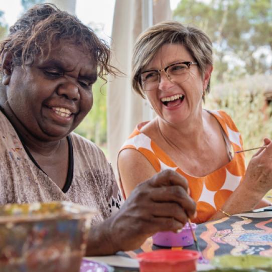 People painting indigenous art with their hands | Voyages Indigenous Tourism