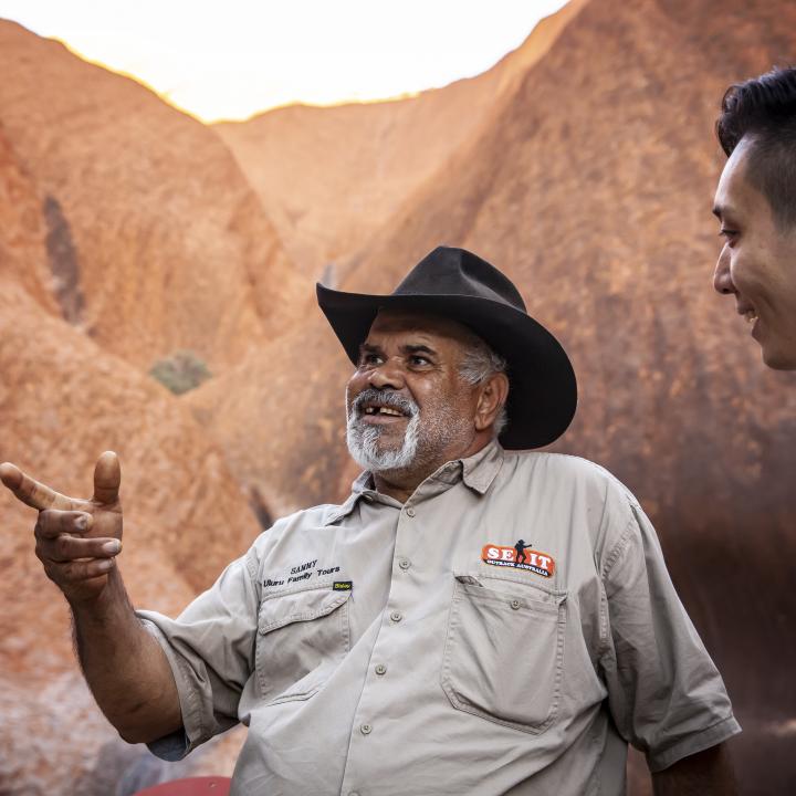 Two men beside Ayers Rock