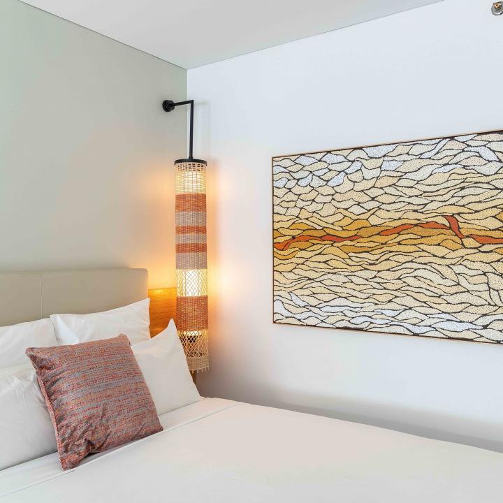 Hotel bed and large abstract painting