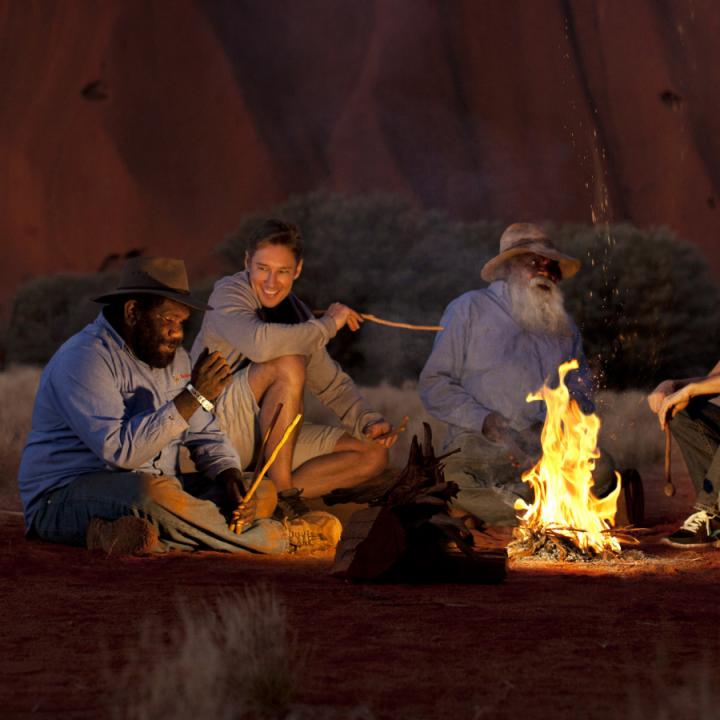 Sitting around a campfire at night | Voyages Indigenous Tourism