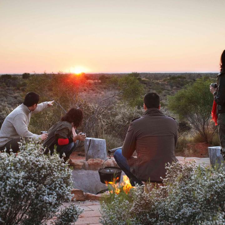 Group having coffee at sunrise at Ayers Rock outback