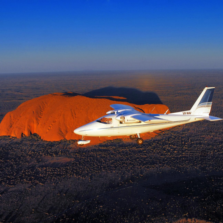 plane in the air over Ayers Rock
