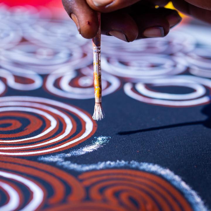 An individual creating indigenous artwork