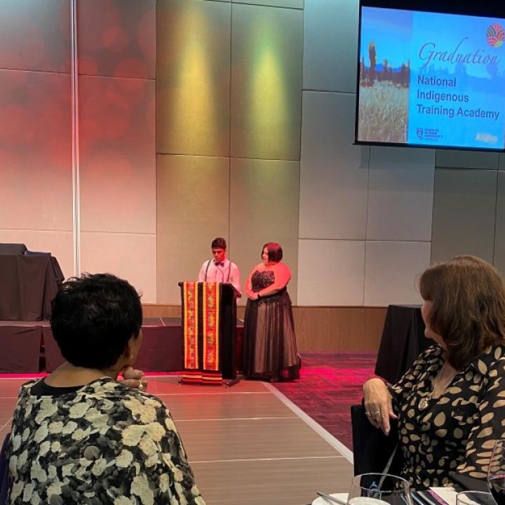 Two individuals presenting an award