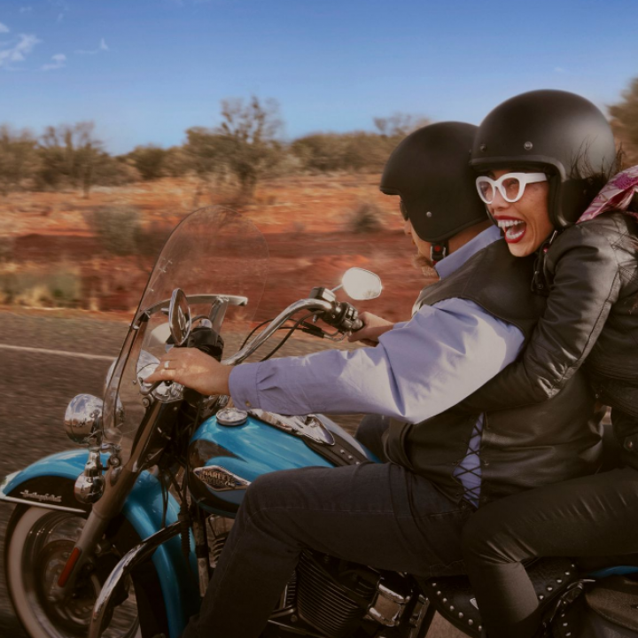 woman riding on the back of a Harley motorcycle