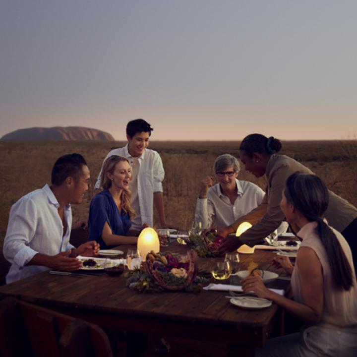 Dining outside with sunset and Uluru