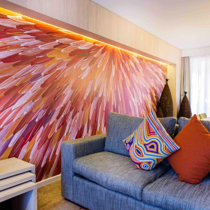 Grey couch next to large painted walk