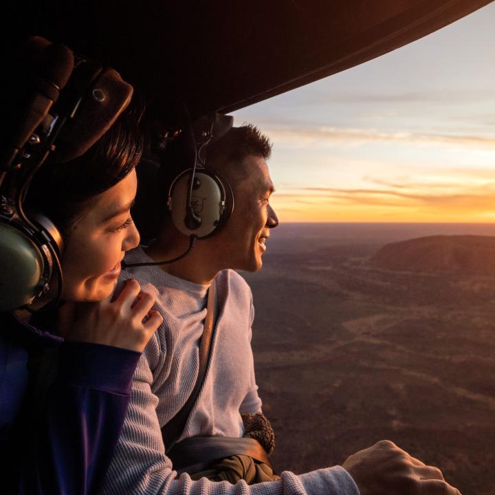 Couple in helicopter flying over Uluru