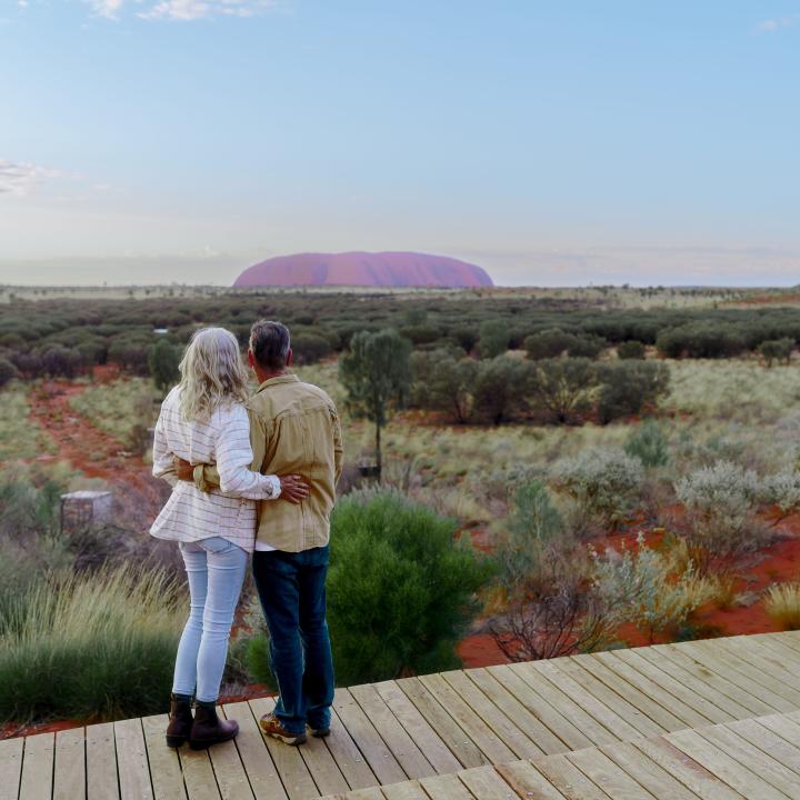A couple looking at Uluru from a deck at Ayers Rock Resort