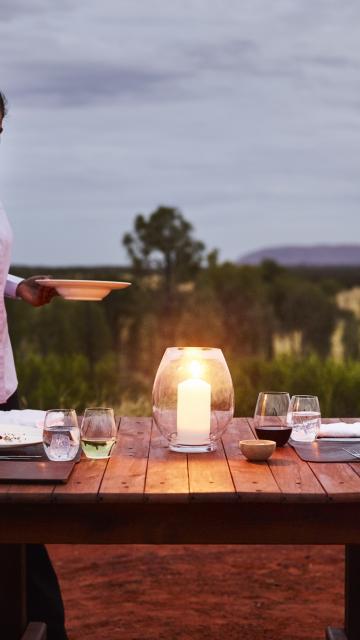 a waitress serving dinner at an outdoor table