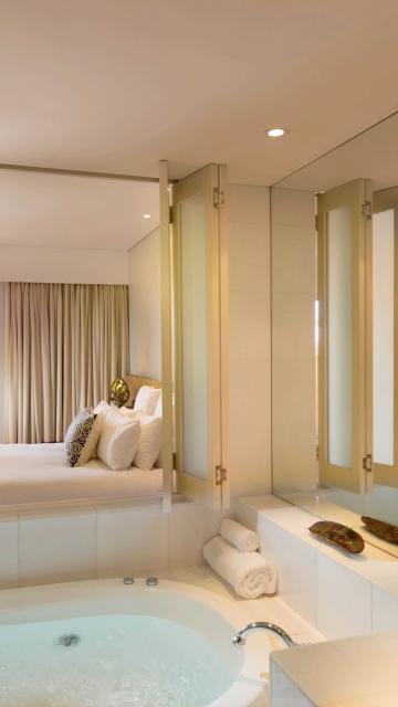 Large soaker tub adjoining luxurious hotel suite bedroom