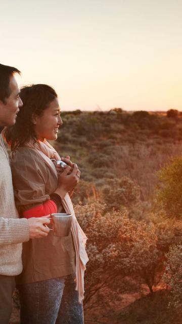 couple enjoy coffee on the outback at sunrise