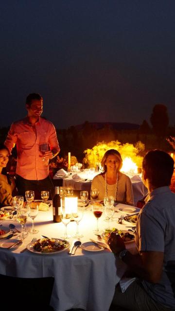 A group of friends enjoying dinner around a table at the Sounds of Silence experience.