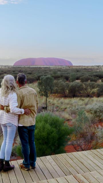 A couple looking at Uluru from a deck at Ayers Rock Resort