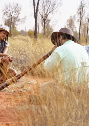 indigenous man playing the didgeridoo