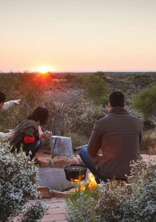 Group having coffee at sunrise at Ayers Rock outback
