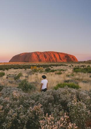 Man looking at Uluru during sunset