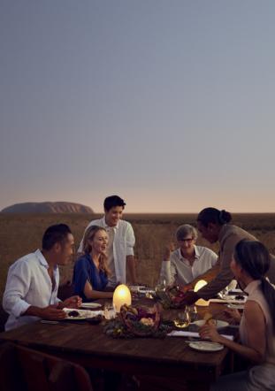 Dining outside with sunset and Uluru