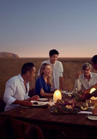 Dining outside with sunset and Uluru